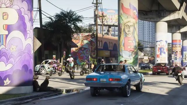 Classic cars and motorcycles under a muralled Vice City overpass