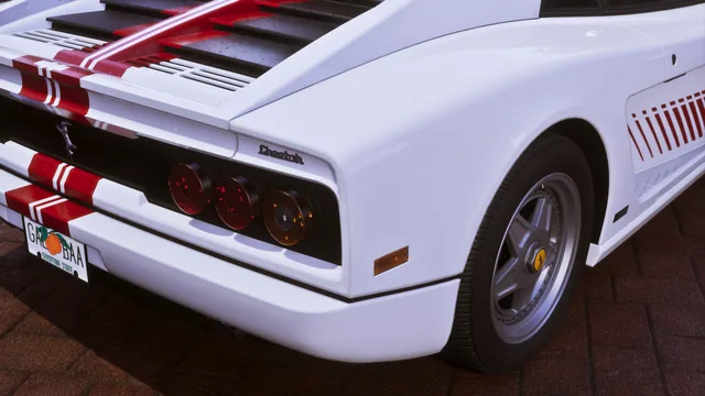 Details of the taillights, the make and model logos, and the license plate of a white Grotti Cheetah with a minimalist, retro-futuristic livery.